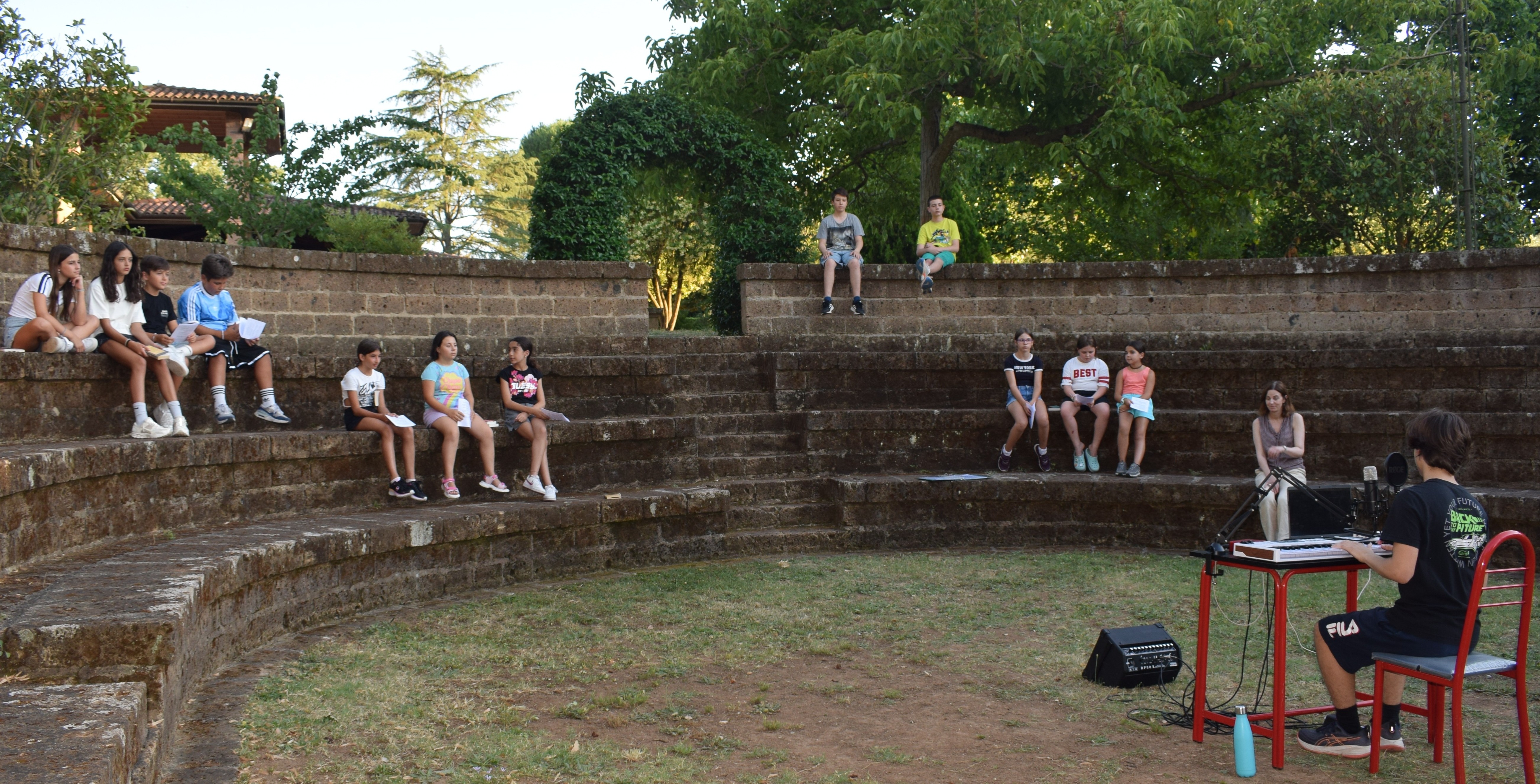 ragazze e ragazzi nell'anfiteatro all'inizio del laboratorio teatrale