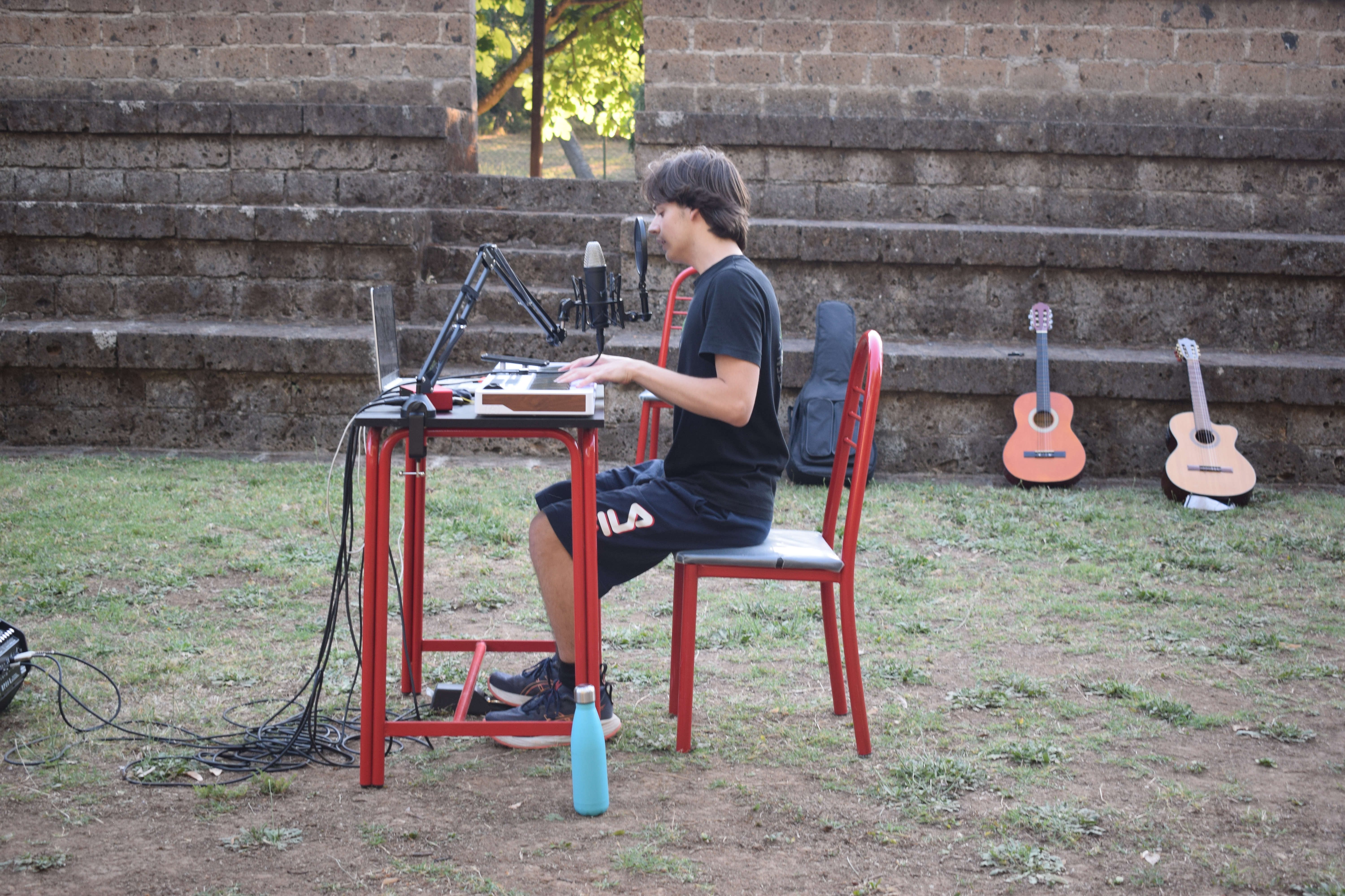 musicista canta e suona seduto alla tastiera